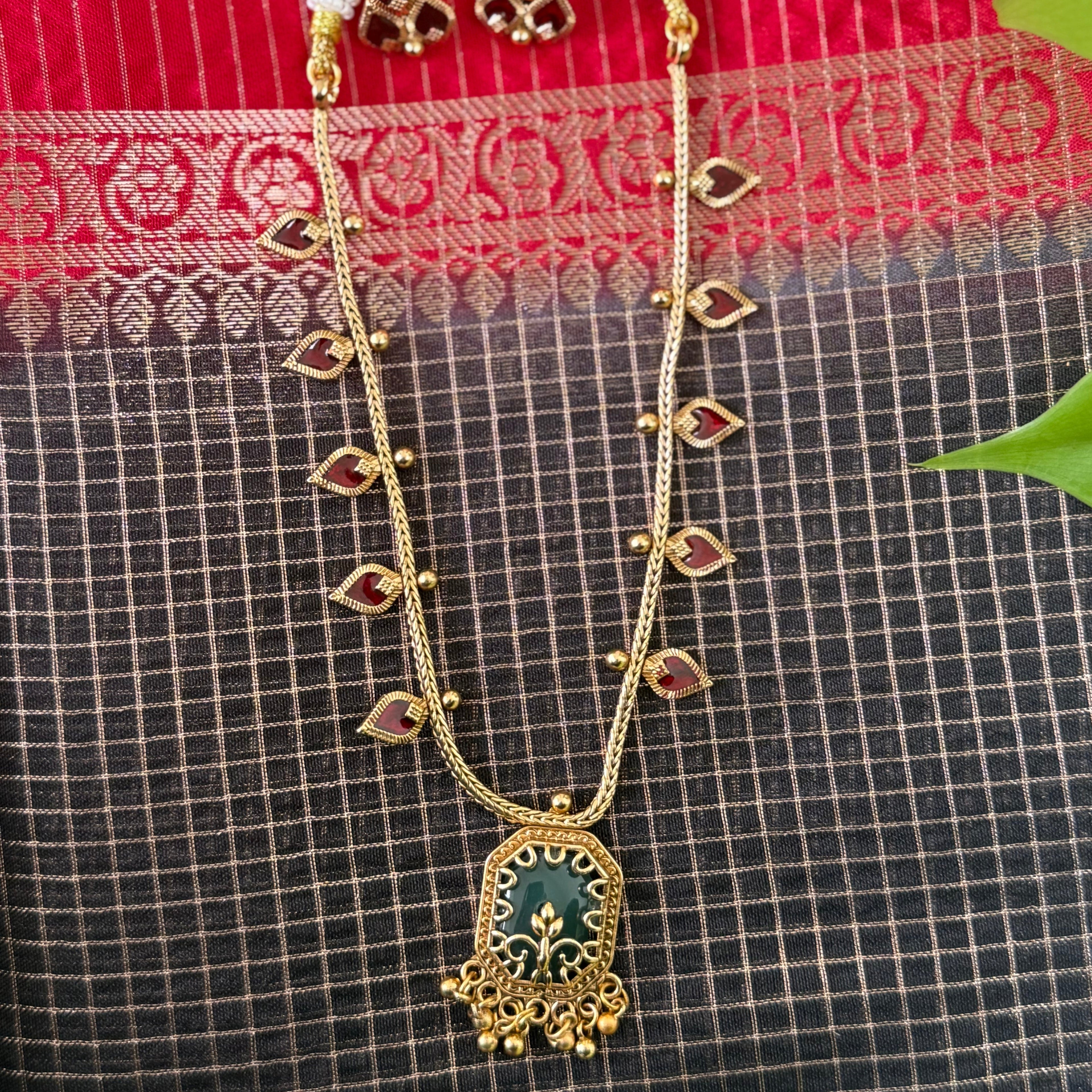 Gold necklace with a green pendant 